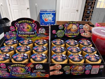 Boxes of Mystery Squishy Dumplings toys on a kitchen counter.