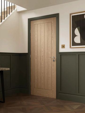 Minimalist wooden door with green trim in a modern interior.