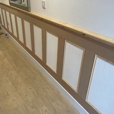 Decorative wall paneling installation in progress with wooden frames.