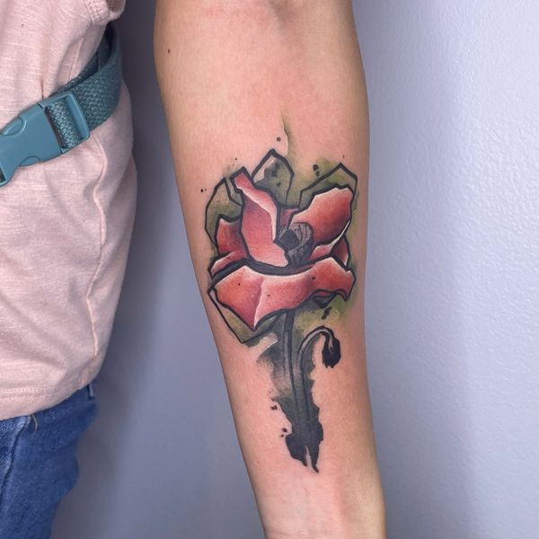 Stylized poppy tattoo on forearm