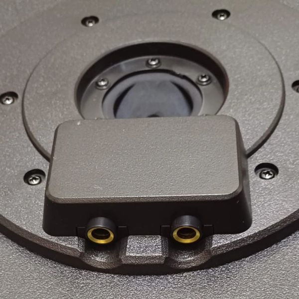 Close-up of a speaker driver with two audio input terminals.