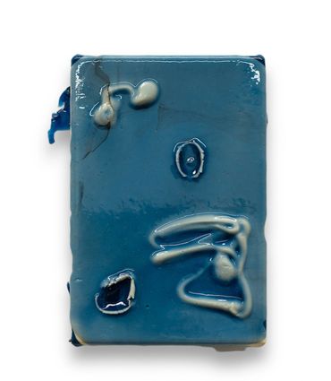 A blue rectangular object with white irregular marks on its surface.