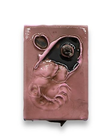 Close-up of a melted, distorted chocolate bar with pink and dark brown areas.