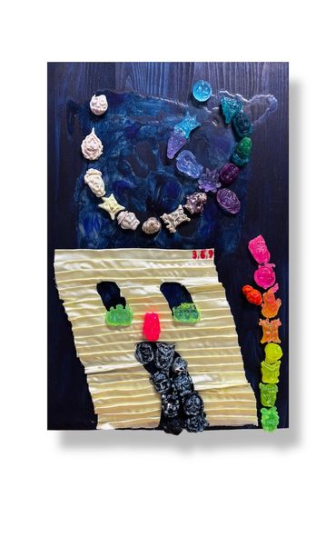 Colorful gummy candies arranged creatively on a dark wooden surface with a textured yellow paper.
