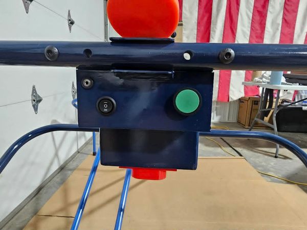 Close-up of a control box with buttons on blue metal frame.