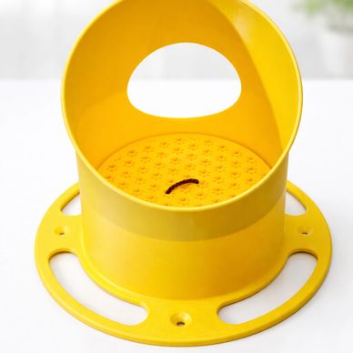 Yellow mosquito coil holder with a lit coil inside.
