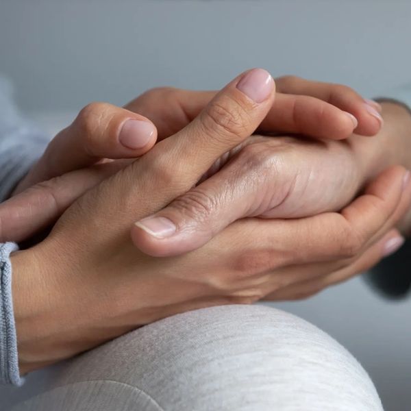 Two people holding hands in a comforting gesture.