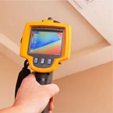 A thermal camera displaying colorful heat signatures on a ceiling.