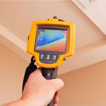 A thermal camera displaying colorful heat signatures on a ceiling.