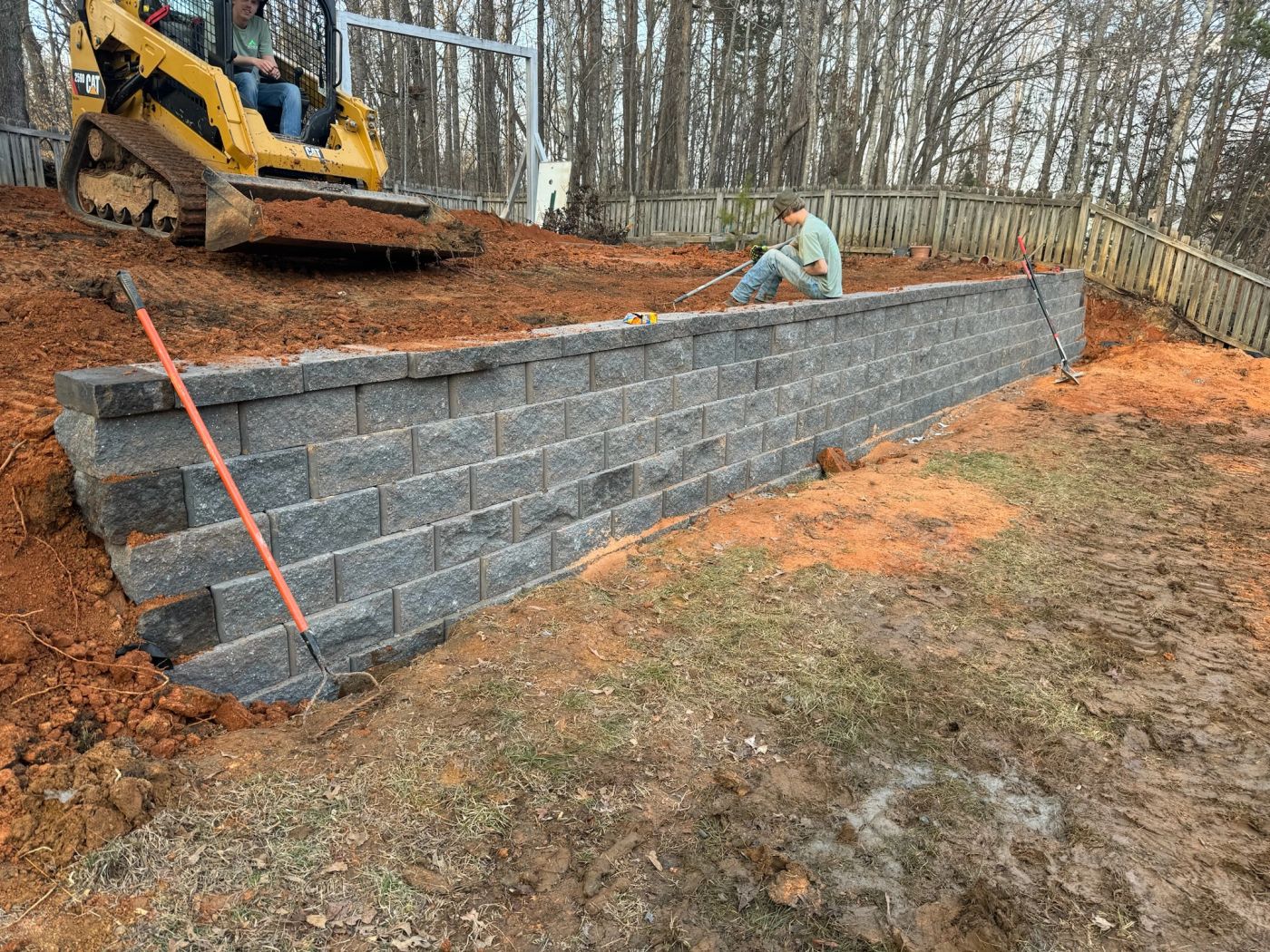 Apex crew setting a block retaining wall on a graded base