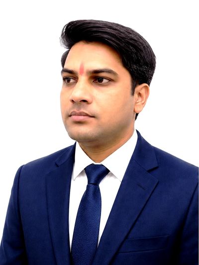 Portrait of a man in a blue suit and tie with a white background.