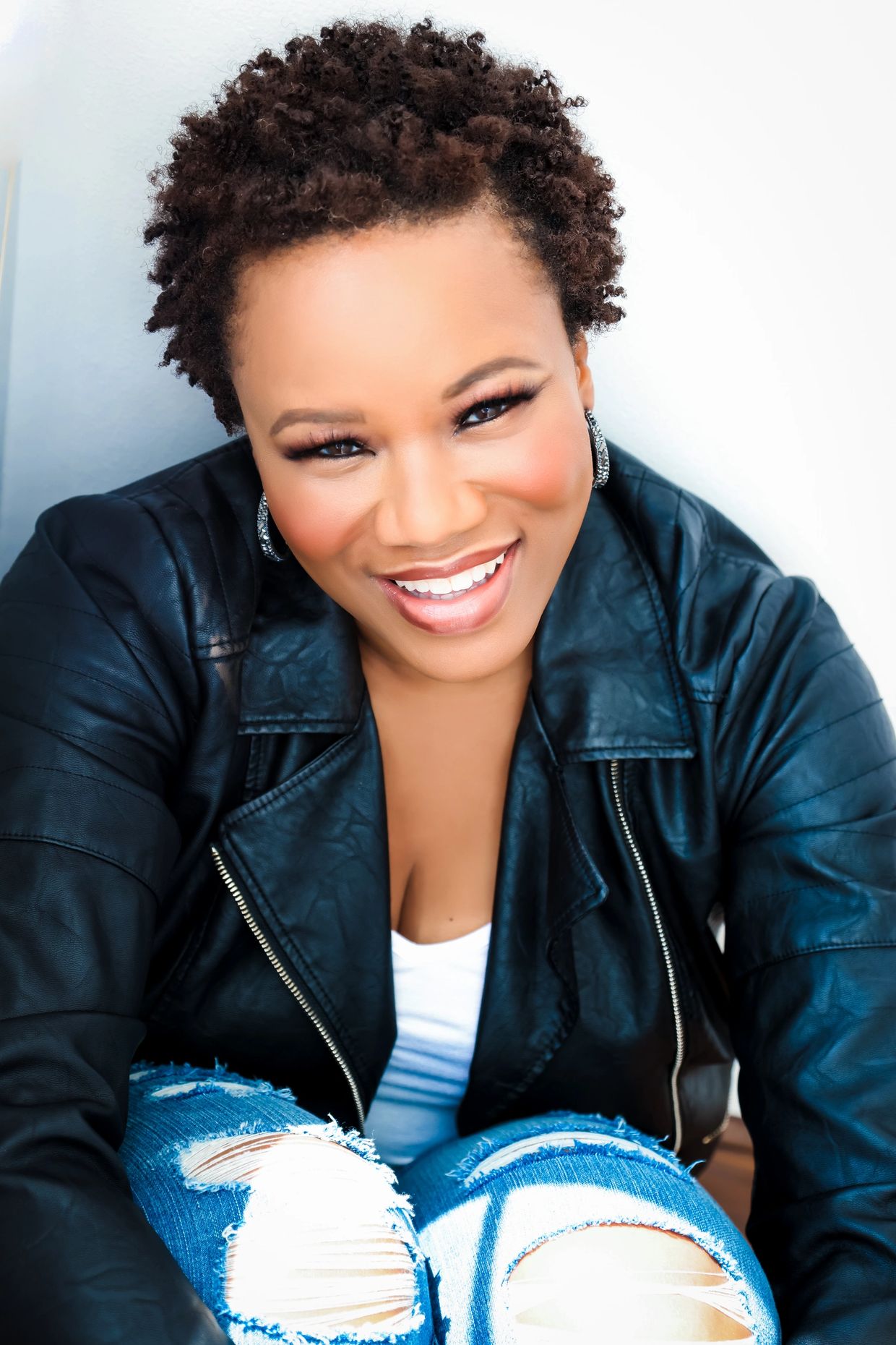 Karla J Noland (African-American woman) sitting and smiling.            