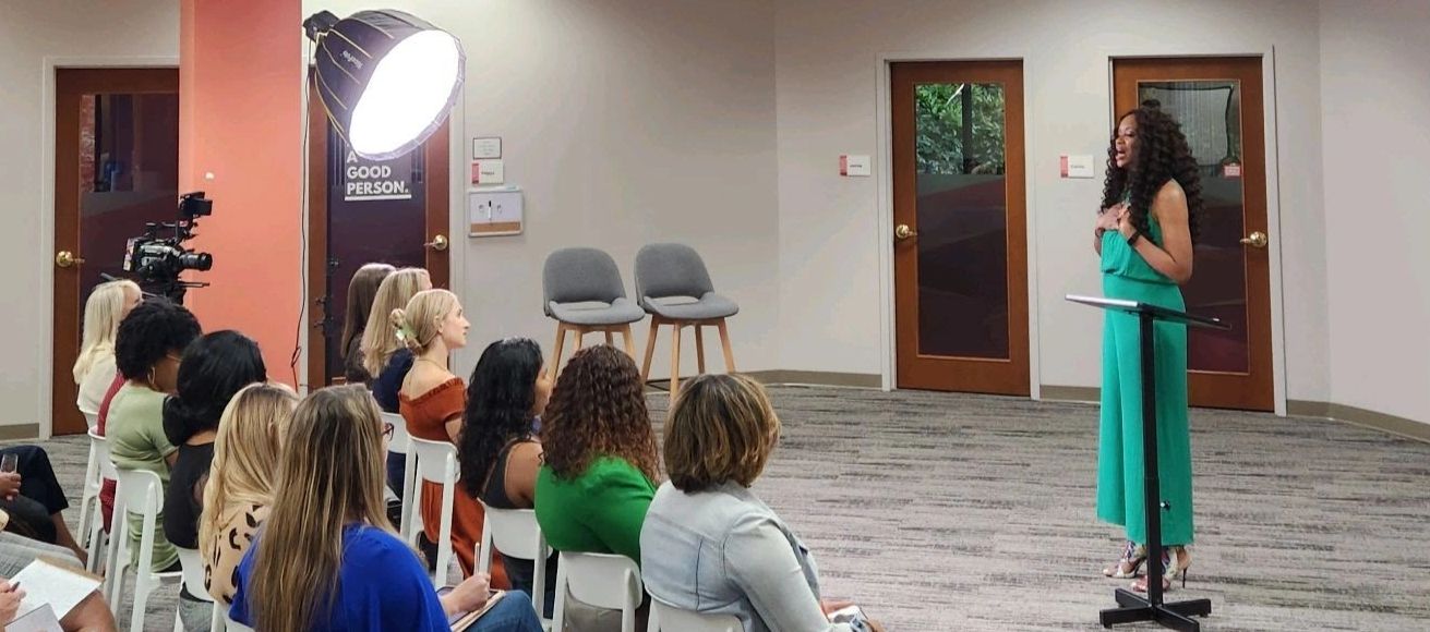 Group of women listening attentively to African American speaker.