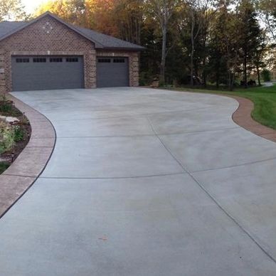 Concrete driveway with a stone paver border for added appearance