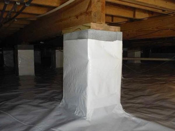 Covered and sealed support pillar in a crawl space with white vapor barrier.