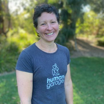Smiling woman in a "human garage" t-shirt outdoors.