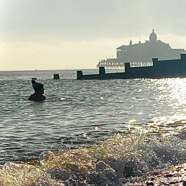 Karen Roberts Life Coach in the sea at Eastbourne wearing a bobble hat
