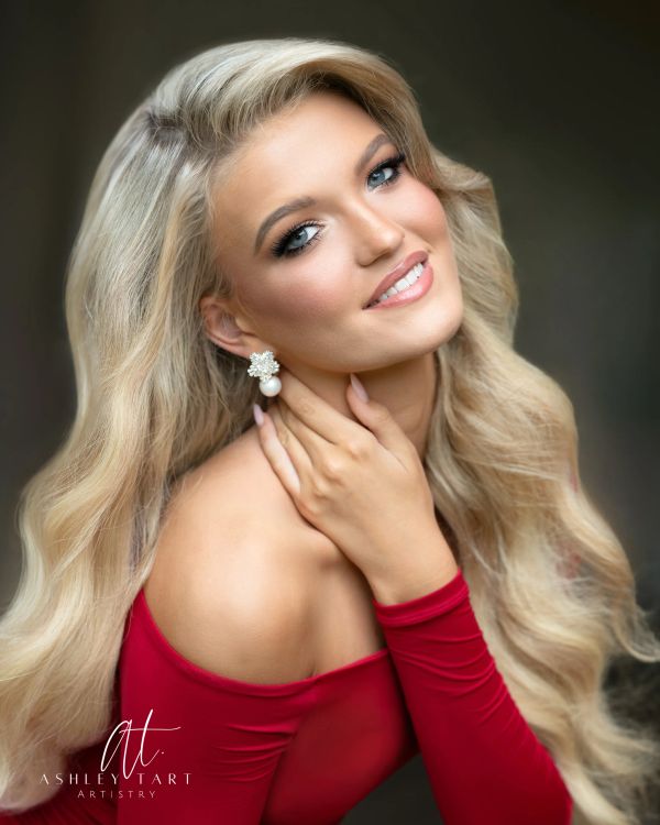 Smiling woman with long blonde hair and red dress.
