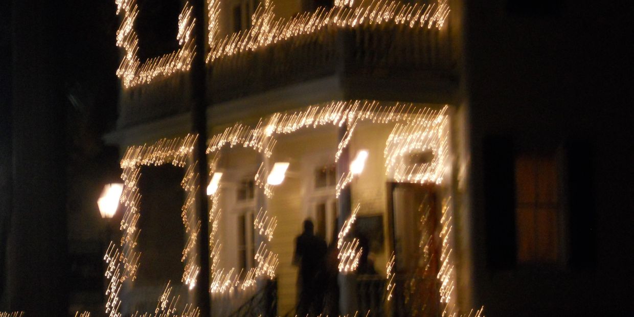 House decorated with string lights at night, blurry image.