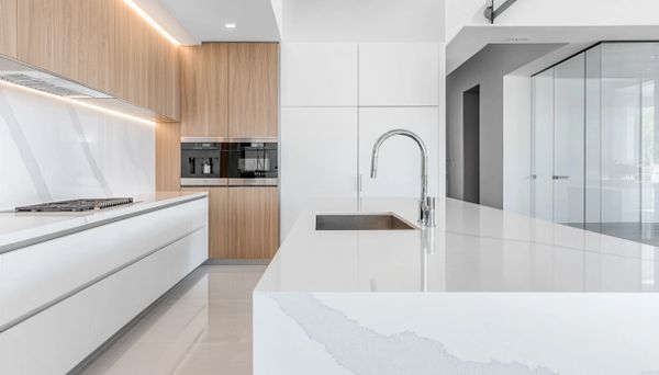 Modern kitchen with white countertops and wooden cabinets.