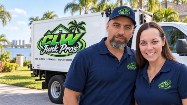 Two CLW Junk Pros employees posing in front of their truck.