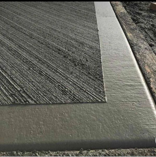 Freshly poured concrete with a textured finish and smooth edge.