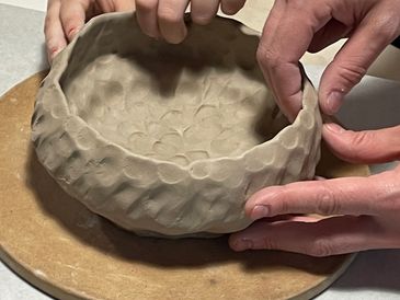 hands making a ceramic bowl