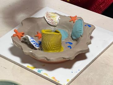 hand-painting a pottery candleholder