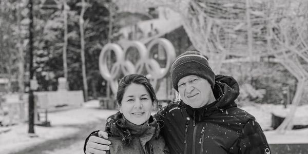 Couple posing in winter with Olympic rings in the background.