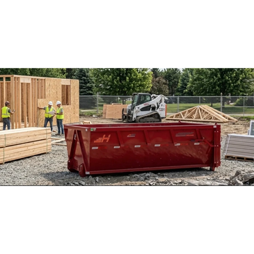Construction site with dumpster and workers framing a wooden structure and equipment.