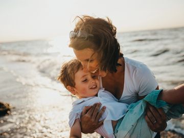 Mum and her son being joyful by the sea 