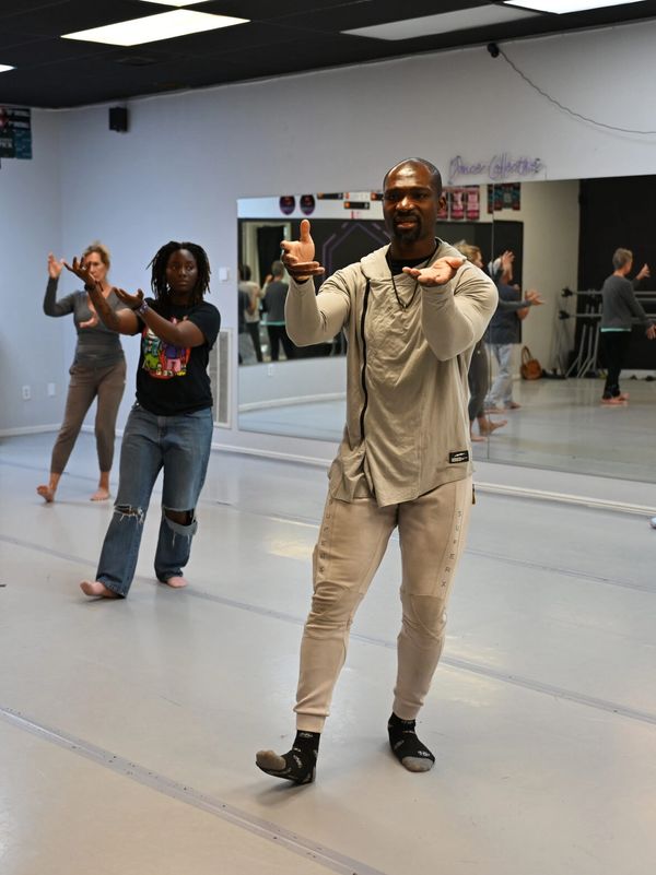 Dance instructor leading a class in a studio.