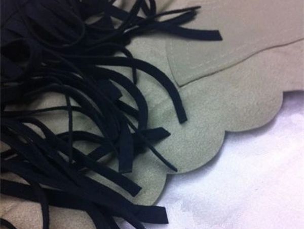 Beige fabric with black fringes.