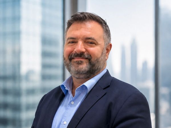 Confident man in business attire with city background.