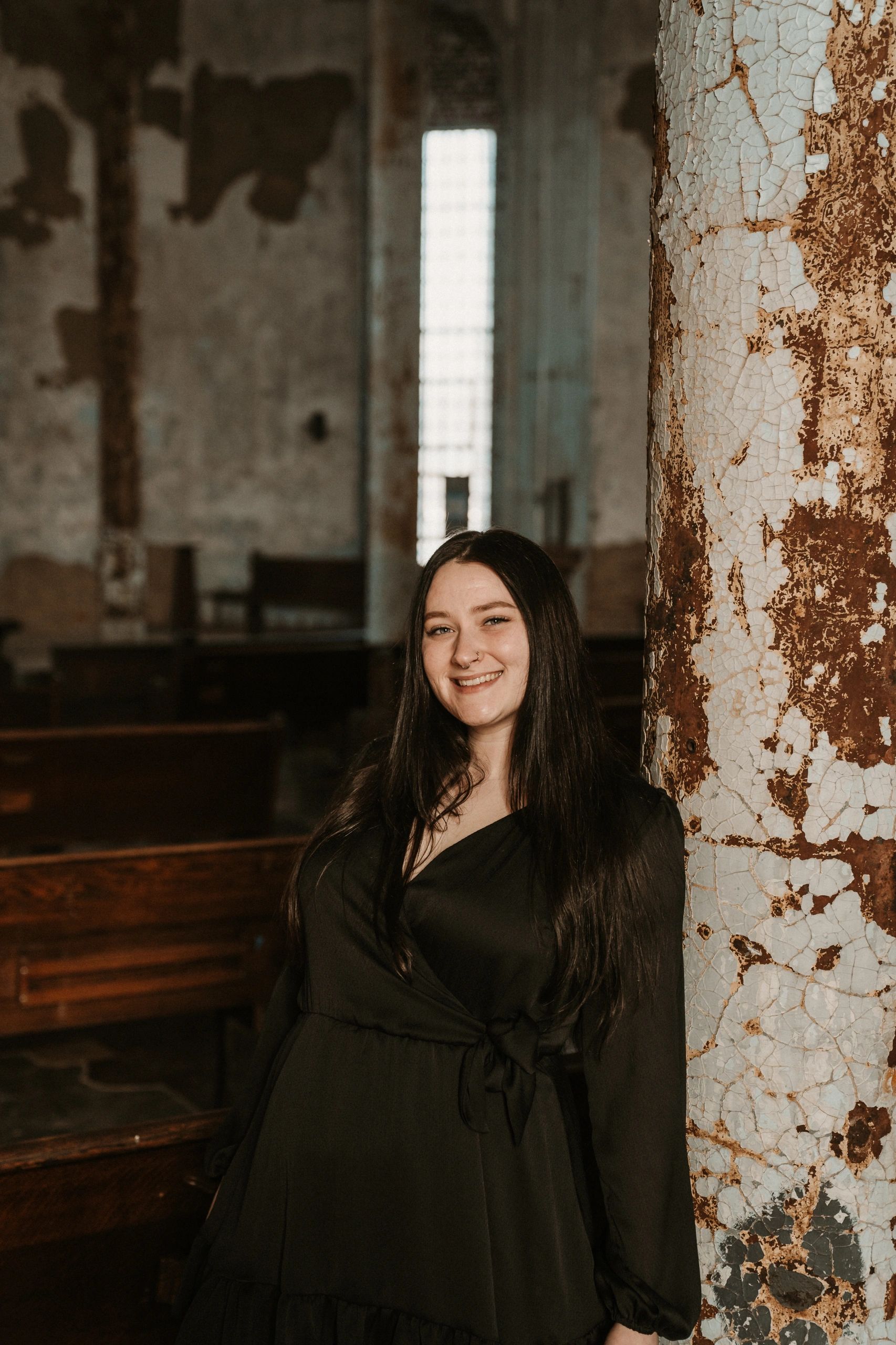 Smiling woman with long black hair in a black dress.
