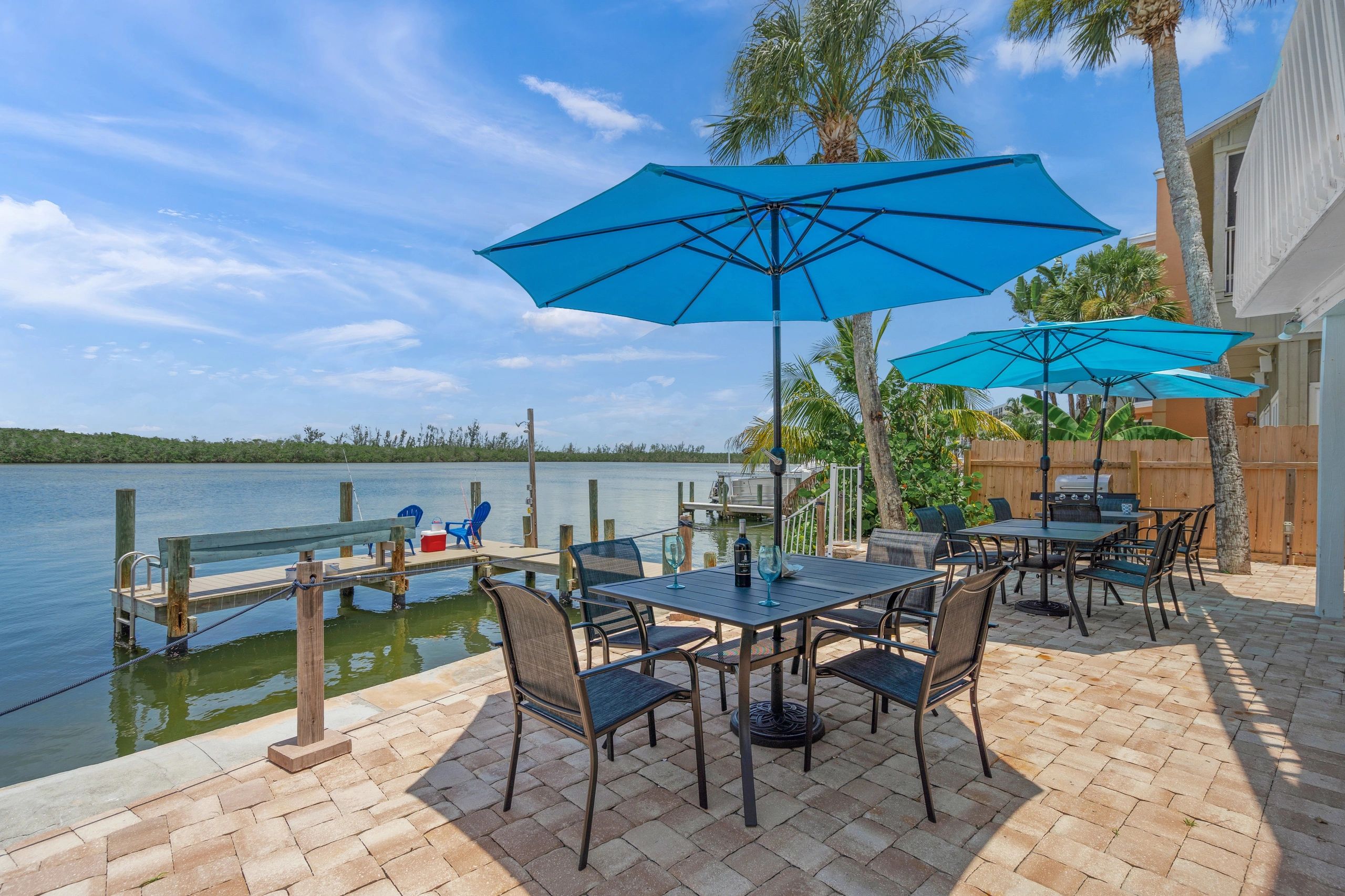 A waterfront patio with tables, chairs, and umbrellas