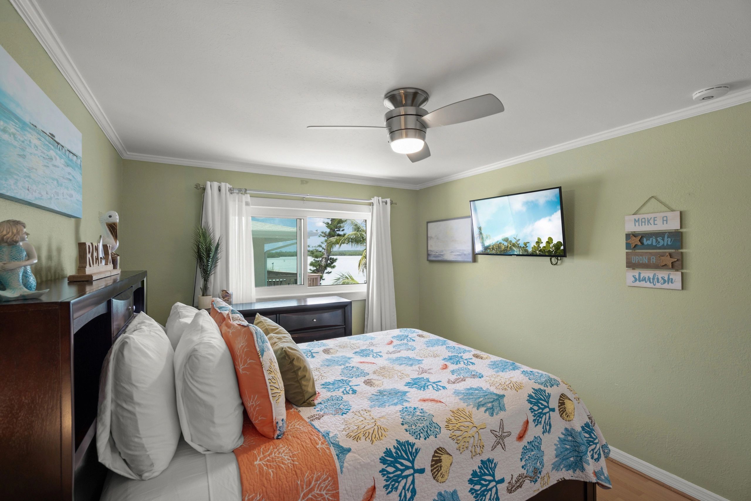 A bedroom with a bed, TV, and window