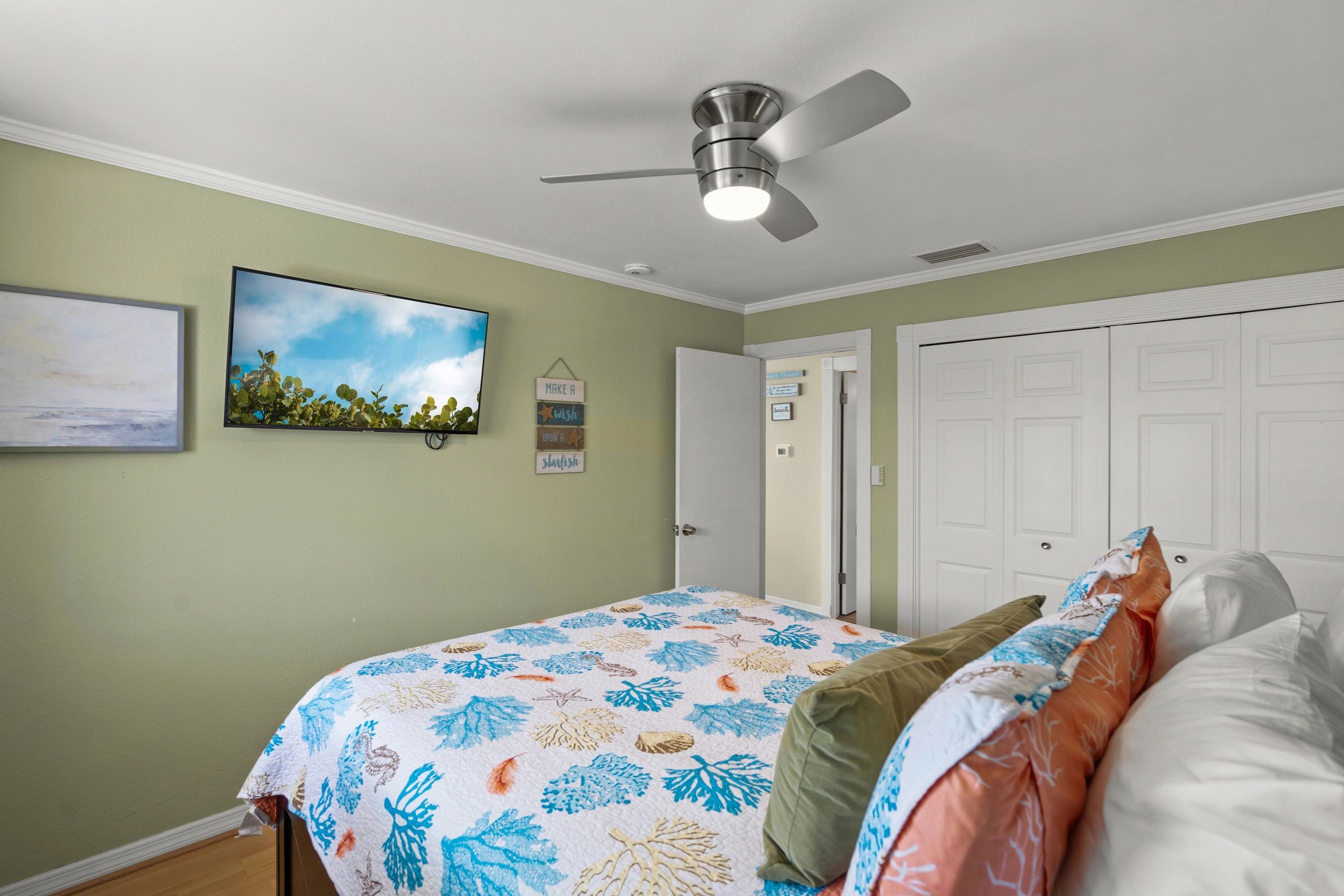 A wide-angle view of a bedroom with a bed, closet, and doorway.