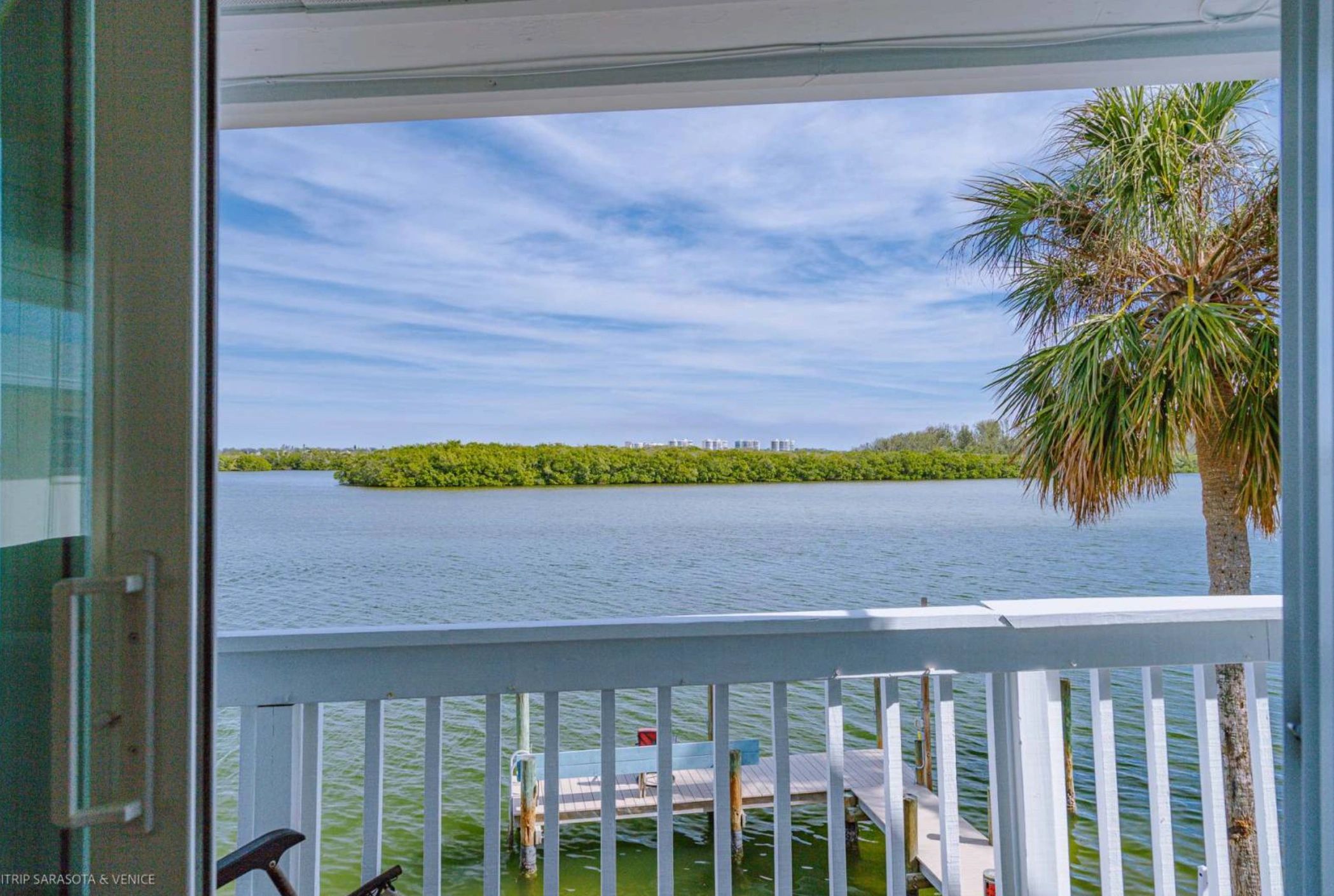 A view of a body of water from a balcony with a white railing.