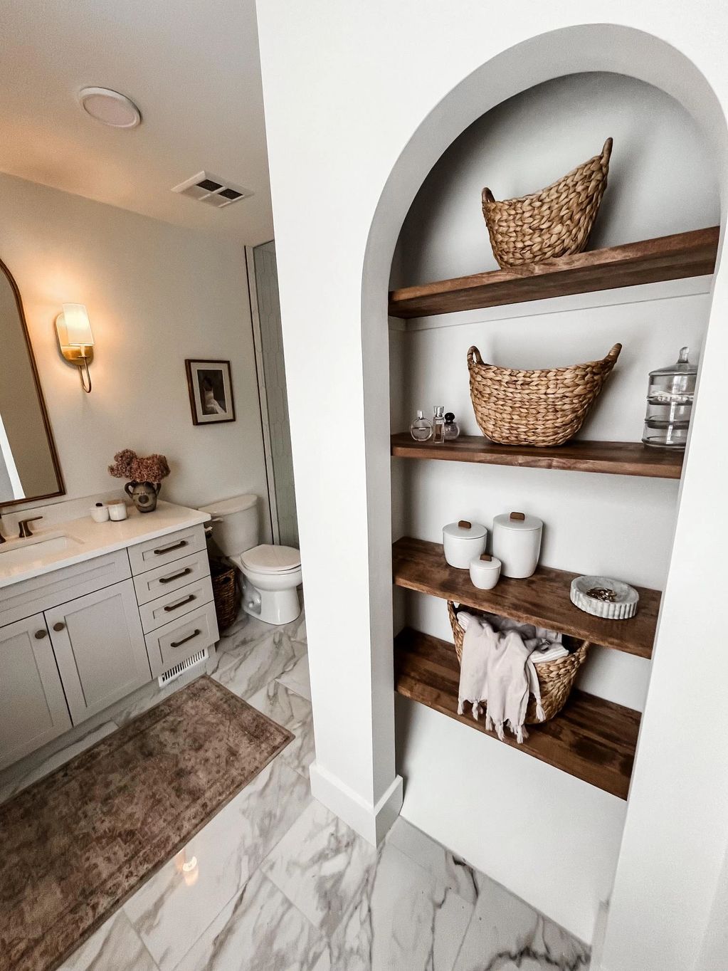 Custom arch open linen closet with wooden shelving.
