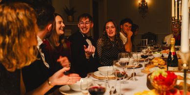 Group of friends enjoying a lively dinner party with wine and laughter.