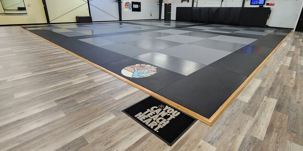 East Carolina Brazilian Jiu-Jitsu academy mat space showing ECBJJ Lifestyle logo.