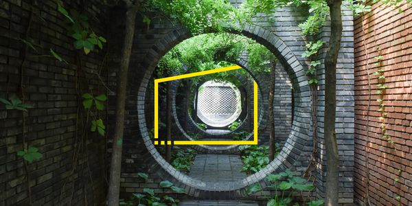 Circular brick tunnel installation surrounded by greenery symbolizing sustainable market economy