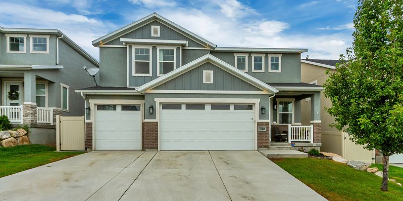 Modern gray two-story house with a large driveway and garage.