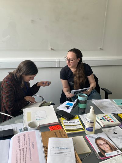 MOLA sight loss awareness training. Two participants having a discussion around a table.