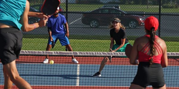 Pickleball tournament information visual of people playing pickleball in a competitive match