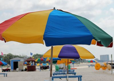 Colorful beach umbrellas and wooden lounge chairs line the Biloxi Beach with casinos in the distant 