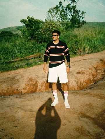 Man standing outdoors on a dirt path.