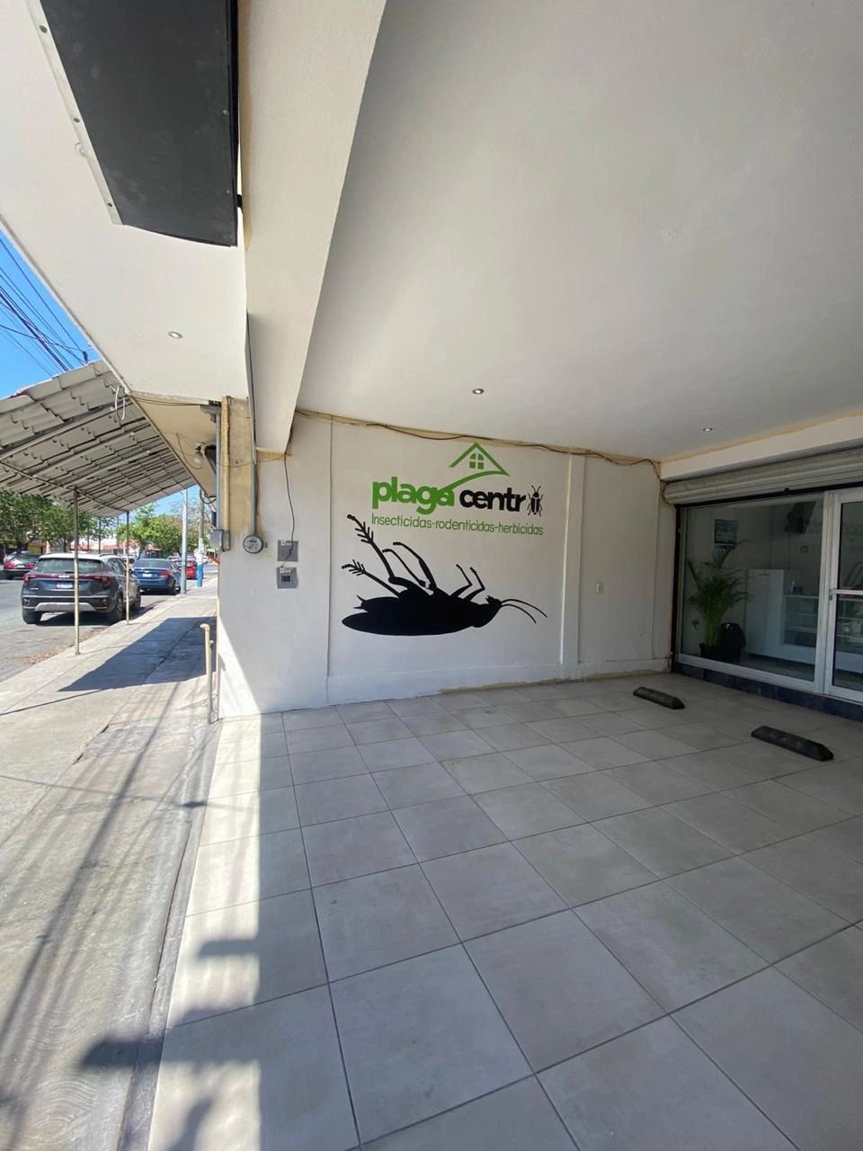 Exterior of a pest control business with a large bug graphic on the wall.