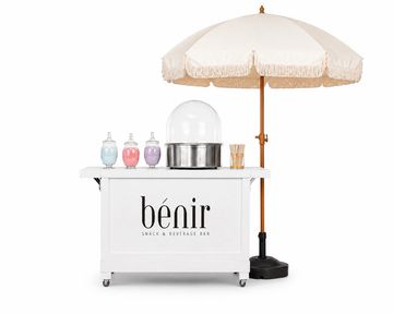 White snack bar cart with umbrella and condiments.